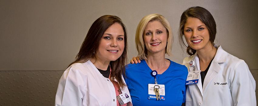 Three Doctor of Nursing Practice (DNP) nurses with their arms around each other in the Emergency Department